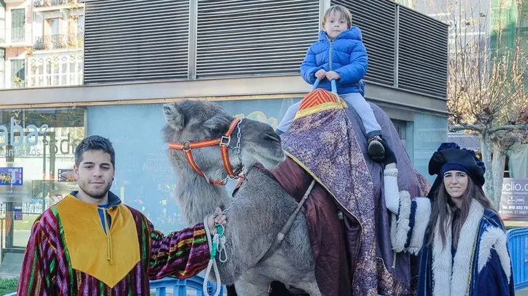 Un niño se pasea con una de las dromedarias reales este sábado en Pamplona.