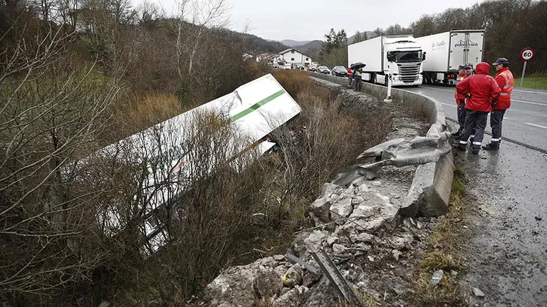 Efectivos de la Policia Foral realizan el atestado del accidente ocurrido esta tarde a la altura de la localidad navarra de Ventas de Arraiz donde el conductor de un cami&oacute;n ha tenido que ser rescatado por los bomberos despu&eacute;s de quedar atrapado en la cabina del veh&iacute;culo que conducia tras caer por un terrapl&eacute;n cuando circulaba por la N-121-A. EFE/Jes&uacute;s Diges