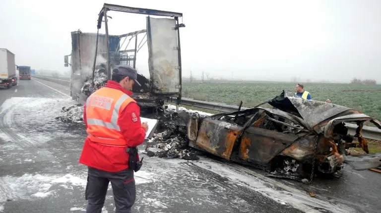 Un policía foral observa los restos de los dos vehículos accidentados.