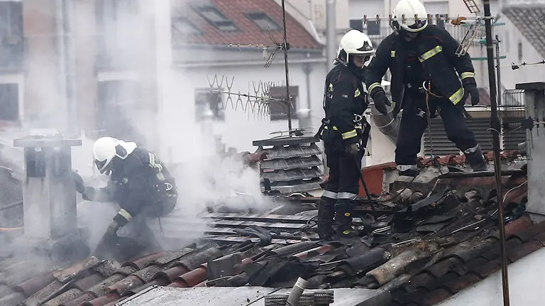 GRA105. PAMPLONA, 28/01/2016.- Un grupo de bomberos sofoca el incendio que se ha producido esta madrugada en una vivienda del casco Viejo de Pamplona a causa del cual cuatro personas, dos vecinas y dos bomberos, han tenido que ser trasladadas al Complejo Hospitalario de Navarra. Una de las personas trasladadas al hospital es la vecina de ese piso, de 22 años, que resultó herida tras lanzarse a un patio interior del edificio para huir de las llamas. El edificio de cinco plantas, en el que viven ocho personas, está situado en el número 12 de la calle del Carmen y ha sido desalojado, al igual que algunas viviendas del portal número 10. EFE/Jesús Diges