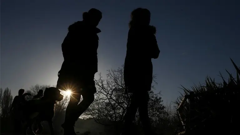 Tiempo, varias personas caminan junto al río Arga durante el atardecer en Pamplona. EFE