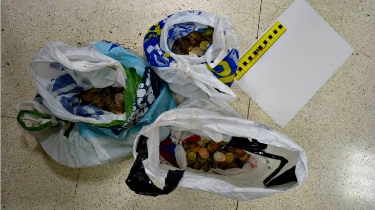 Bolsas de plástico llenas de monedas localizadas en las inmediaciones.