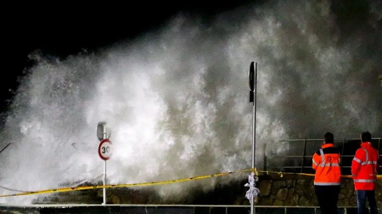 Una gran ola rompe contra el Paseo Nuevo de San Sebastián provocando que el agua inunde algunas calles de la Parte Vieja donostiarra. EFE.
