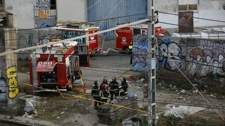 Varios operarios y bomberos trabajan en las vias a la altura de Glorias después de que el servicio de trenes haya quedado interrumpido en la red de cercanías de Barcelona. EFE.