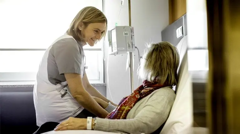 Una enfermera atiende a una paciente en el hospital.