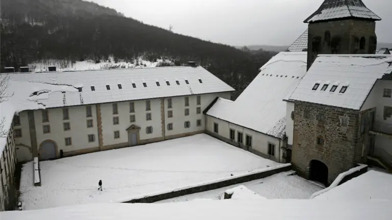 Una persona camina por el interior de la Colegiata de Roncesvalles donde la nieve caida durante esta madrugada ha vuelto a cubrir los montes del norte de la comunidad foral. EFEJesús Diges