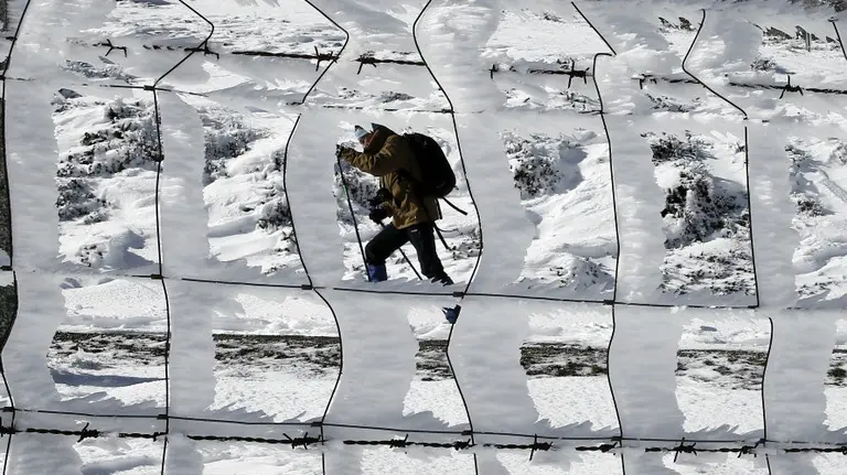 Una persona pasea por el alto de Ibañeta donde la nieve caida durante esta madrugada ha vuelto a cubrir los montes del norte de la comunidad foral. EFEJesús Diges