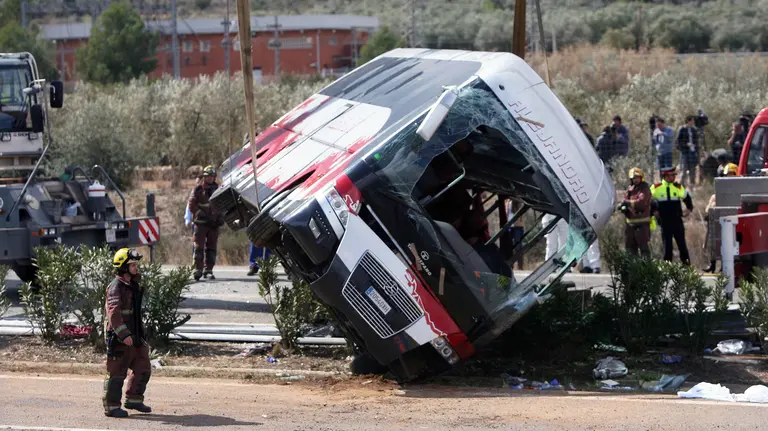 GRA013. FREGINALS (TARRAGONA), 20/03/2016.- Efectivos del cuerpo de bomberos en el momento de levantar el autocar perteneciente a la empresa de Mollet del Vallès (Barcelona), que esta mañana ha chocado contra un vehículo en la autopista AP-7, a la altura de Freginals (Tarragona). Trece chicas de varias nacionalidades, en su mayoría estudiantes de Erasmus vinculadas a la Universidad de Barcelona, han fallecido en el accidente, otras 28 personas se encuentran heridas, 9 de ellas graves -de una de ellas se teme por su vida- y 21 personas han salido ilesas. EFE/Jaume Sellart