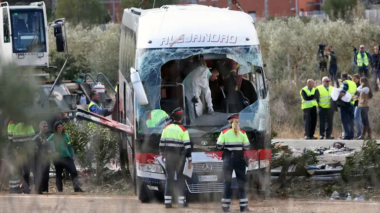 GRA167. FREGINALS (TARRAGONA), 20/03/2016.- Agentes de los Mossos d'Esquadra junto al autocar perteneciente a una empresa de Mollet del Vallès (Barcelona), que esta mañana ha chocado contra un vehículo en la autopista AP-7, a la altura de Freginals (Tarragona). Trece chicas de varias nacionalidades, en su mayoría estudiantes de Erasmus vinculadas a la Universidad de Barcelona, han fallecido en el accidente, otras 28 personas se encuentran heridas, 9 de ellas graves -de una de ellas se teme por su vida- y 21 personas han salido ilesas. EFE/Jaume Sellart