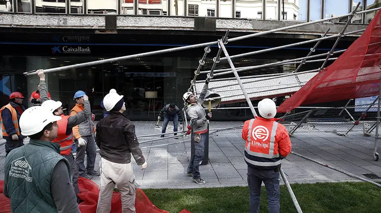 Un grupo de trabajadores desmontan el andamio que estaban levantando sobre un edificio de Pamplona y que ha sido derribado esta tarde a causa del fuerte viento que durante todo el día ha soplado en la capital navarra. En el momento de caer el andamio los trabajadores se encontraban comiento por lo que no hay heridos. EFE/Jesús Diges