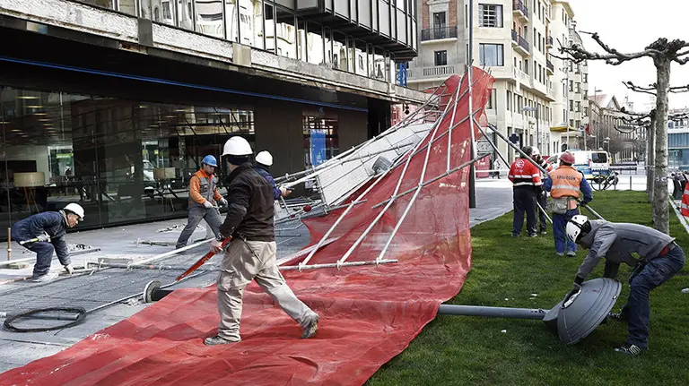 GRA351. PAMPLONA, 23/03/2016.- Un grupo de trabajadores desmontan el andamio que estaban levantando sobre un edificio de Pamplona y que ha sido derribado esta tarde a causa del fuerte viento que durante todo el día ha soplado en la capital navarra. En el momento de caer el andamio los trabajadores se encontraban comiento por lo que no hay heridos. EFE/Jesús Diges