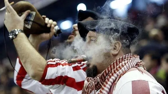 Aficionados bebiendo y fumando un puro en San Mamés. EFE