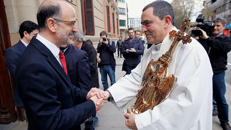 El parlamentario de UPN Alberto Catalán (i) saludal al capellán del santuario de Aralar, Mikel Garciandia, a su llegada al Parlamento de Navarra dentro del recorrido que el Ángel de Aralar realiza por diversas instituciones. EFE/Ivan Aguinaga