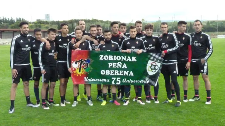 Osasuna posa con la pancarta de la Peña Oberena 75 años.