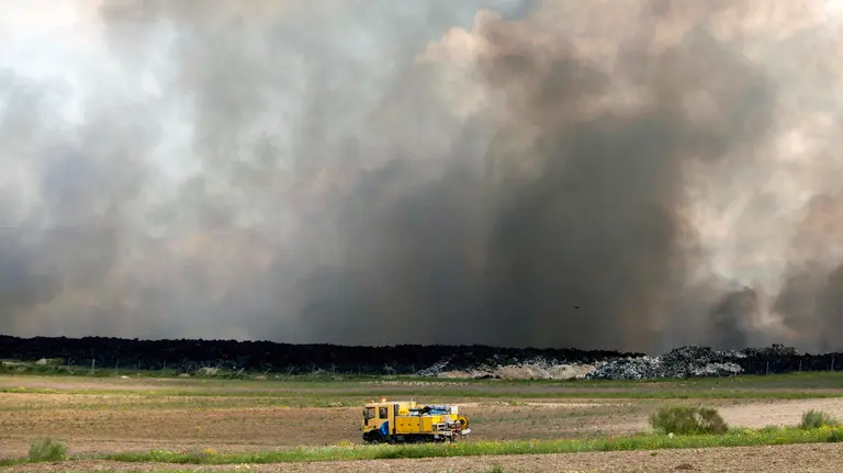 GRA203. SESEÑA (TOLEDO), 14/05/2016.- Equipos de Emergencias de Castilla-La Mancha en labores de extinción del incendio producido ayer en el cementerio de neumáticos de Seseña (Toledo), un tercio del cual se encuentra en el término municipal de Valdemoro (Madrid) y que acumula miles de toneladas de ruedas. La Comunidad de Madrid ha rebajado hoy a 0 el nivel de alerta por el incendio de la planta de neumáticos en Seseña y ha pedido tranquilidad a los vecinos de los municipios aledaños puesto que la calidad del aire es normal y las previsiones meteorológicas hacen prever que la situación no empeorará. EFE/Héctor Martín
