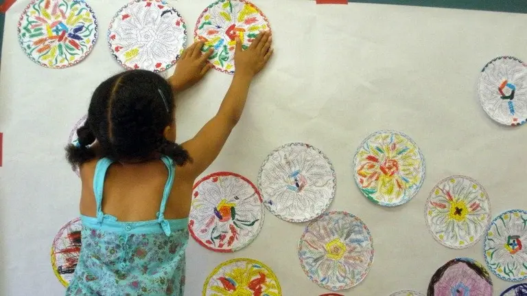 Una niña realiza manualidades en algún curso.