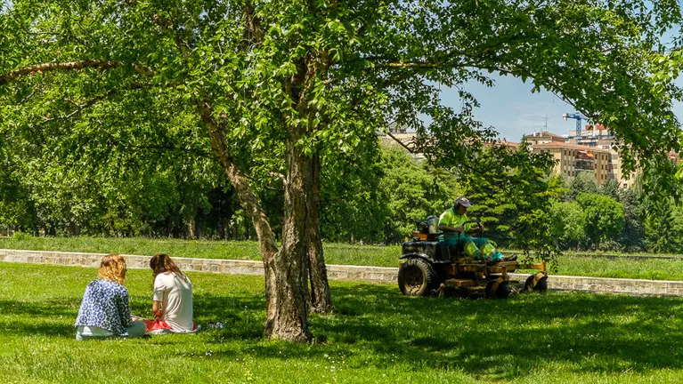 Tiempo. Un operario de jardines corta la hierba en la Vuelta del Castillo de Pamplona. IÑIGO ALZUGARAY