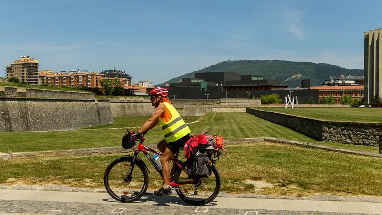 Un peregrino circula en bicicleta por la Vuelta del Castillo de Pamplona. IÑIGO ALZUGARAY