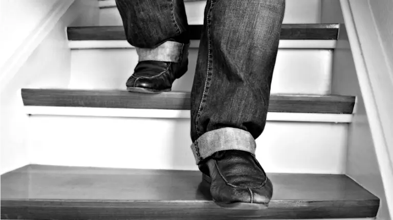 Una persona bajando las escaleras de una vivienda.