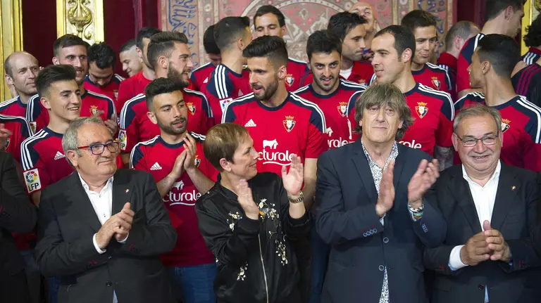 GRA371. PAMPLONA, 19/06/2016.- La presidenta del Gobierno de Navarra, Uxue Barkos (c), junto al presidente del Osasuna, Luis Sabalza (i), el entrenador Enrique Martín (2d), los jugadores del Osasuna y el cuerpo técnico, durante la recepción que el Ejecutivo foral les ha dispensado esta tarde en el Palacio de Navarra, en un acto en el que Barkos ha puesto hoy al conjunto navarro como "ejemplo" de saber sacar "lo mejor de sí mismo y de confiar en sus propias fuerzas" y por su "modo y manera de trabajar", al lograr ayer el ascenso a Primera División. EFE/Villar López