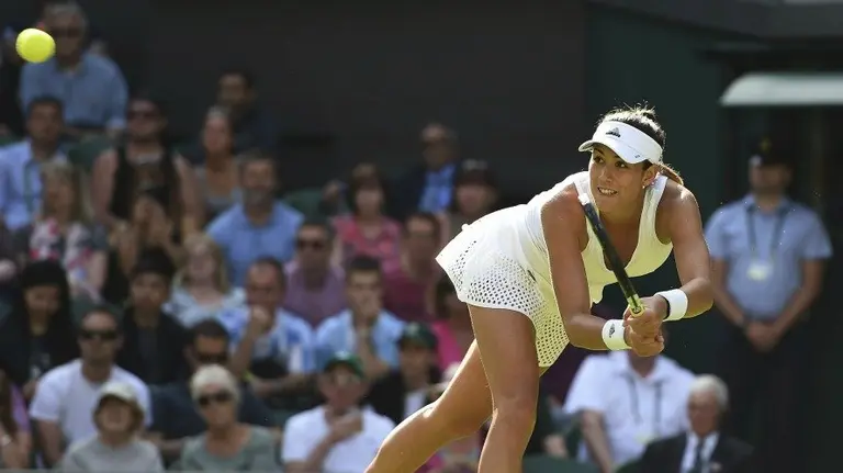 Garbiñe Muguruza  devuelve la bola a la italiana Camila Girorgi  en Wimbledon. EFE