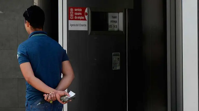 Un joven espera en la puerta del Servicio Navarro de Empleo.