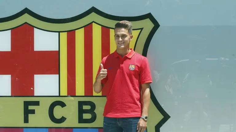 Denis Suárez posa junto al escudo del Barça. Efe.
