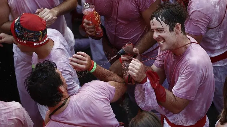 Varias personas festejan el inicio de las Fiestas de San Fermín 2016 tras el lanzamiento del tradicional chupinazo desde el balcón del Ayuntamiento de Pamplona. EFE. JESÚS DIGES