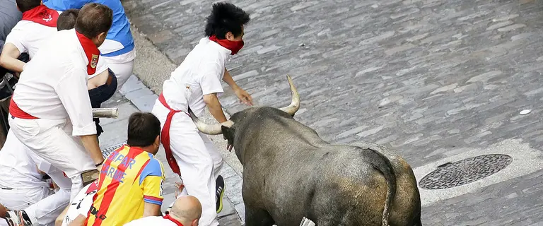Momento de la cogida al joven japonés en la cuesta de Santo Domingo. MIGUEL FERNÁNDEZ