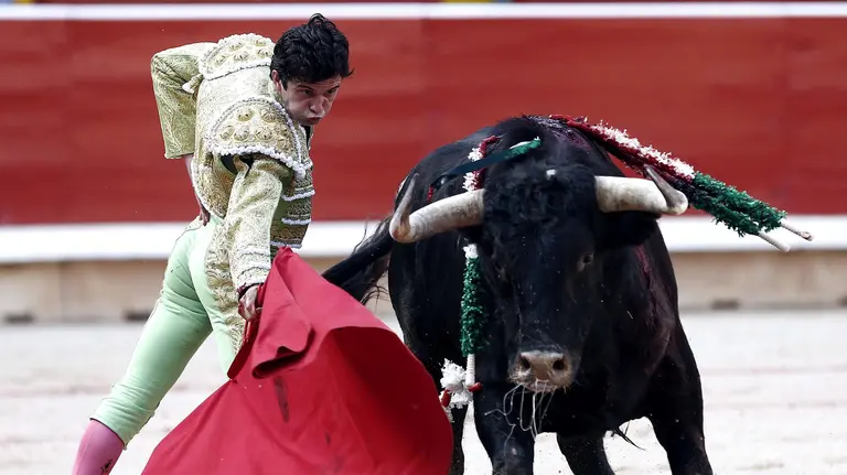 El diestro Juan del Álamo da un pase con la muleta al primero de su lote durante la cuarta corrida de la Feria de San Fermín celebrada esta tarde en la plaza de toros de Pamplona, donde han compartido cartel Curro Díaz e Ivan Fandiño. EFE/Jesús Diges