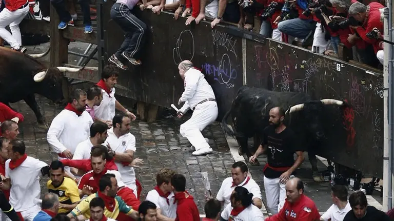 Dos toros de la ganadería de Núñez del Cuvillo entran en la curva de Mercaderes durante el séptimo encierro de los sanfermines 2016. EFE.Jesús Diges (1)