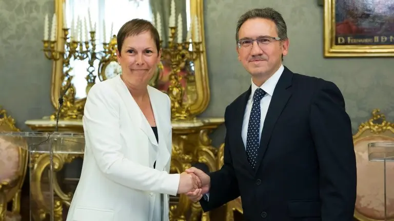 Uxue Barkos y Jaume Giró se saludan tras la firma del convenio. 