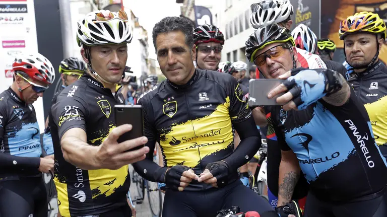GRA013. VILLAVA (NAVARRA), 23/07/2016.- El pentacampeón del Tour de Francia, Miguel Induráin (c), se fotografía con varios corredores momentos antes de dar comienzo de la marcha cicloturista que lleva su nombre, más conocida como 'La Induráin' que hoy cumple su edición número 25, con la participación de 1.800 corredores, y que se creó en 1992 en homenaje al primero de los cinco Tour de Francia logrados por el ciclista navarro Miguel Induráin. EFE/Villar López