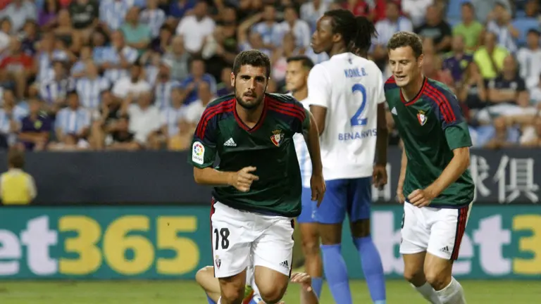 El centrocampista del Club Atletico Osasuna, Fran Mérida (c), celebra el gol del empate frente al Málaga CF, durante el partido de la primera jornada de Liga en Primera División que se disputa esta noche en el estadio de La Rosaleda, en Málaga. EFE/Carlos Díaz.