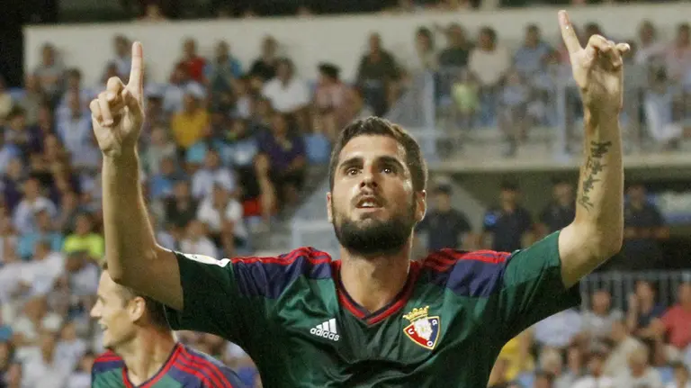 El centrocampista del Club Atletico Osasuna, Fran Mérida (c), celebra el gol del empate frente al Málaga CF, durante el partido de la primera jornada de Liga en Primera División que se disputa esta noche en el estadio de La Rosaleda, en Málaga. EFE/Carlos Díaz.