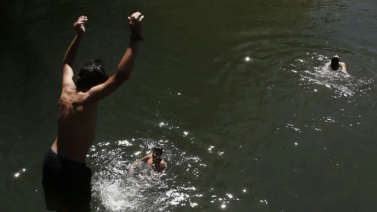 Un grupo de jóvenes se bañan en el rio Arga. Las imágenes del tiempo marcado por el calor vivido en Pamplona. EFE/Jesús Diges
