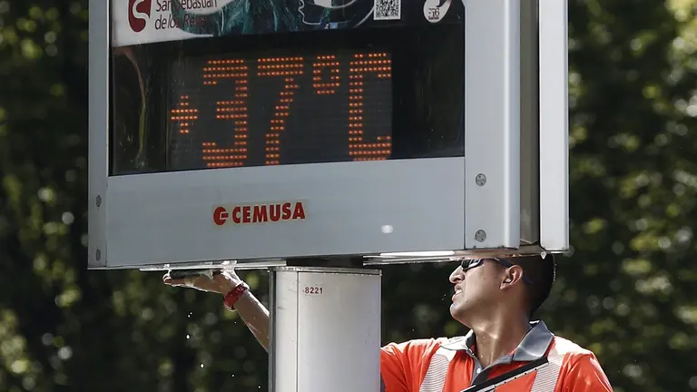 Un trabajador limpia la marquesina de un anuncio publicitario en el centro de Pamplona bajo el sol. Las imágenes del tiempo marcado por el calor vivido en Pamplona. EFE/Jesús Diges