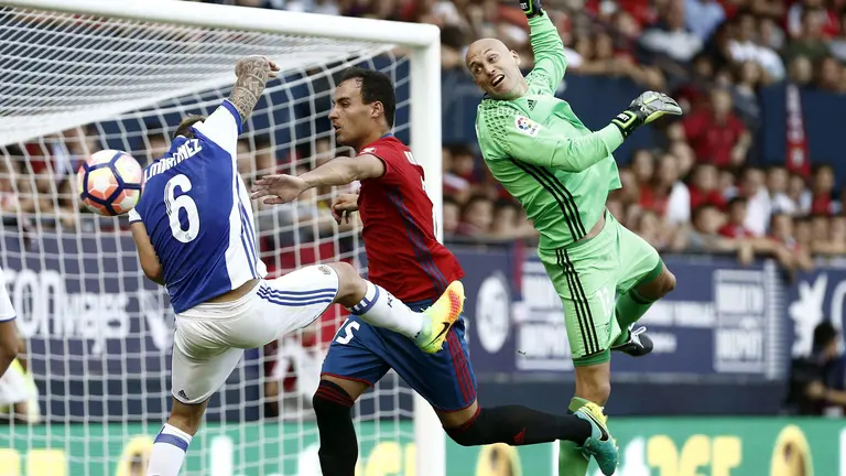 El portero de Osasuna Nauzet, despeja el balón ante su compañero Unai Garcia y Martinez de la Real Sociedad durante el partido de la segunda jornada de Liga en Primera División que ha enfrentado a ambos equipos. EFE/Jesús Diges