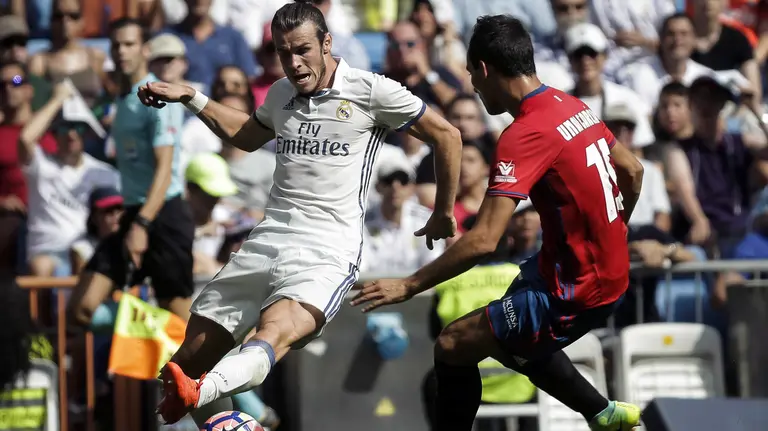 GRA262. MADRID, 10/09/2016.- El delantero galés del Real Madrid Gareth Bale (i) con el balón ante el defensa del Osasuna Unai García durante el partido de la tercera jornada de Liga que disputan frente al Osasuna en el estadio Santiago Bernabéu de Madrid. EFE/Emilio Naranjo