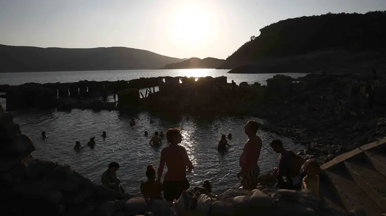 Varios grupos de turistas ha aprovechado el buen tiempo para acercarse a la zona de termas descubierta por la escasez de agua del embalse de Yesa. EFE/Jesús Diges