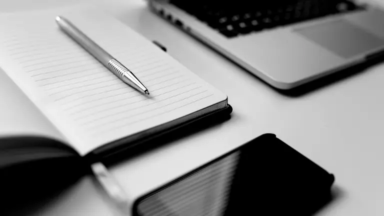 Una persona trabaja con un móvil y un ordenador. LLUIS LLERENA