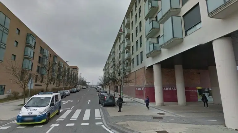 La Policía Municipal circula por el barrio de Buztintxuri, en Pamplona, frente a un bloque de pisos con balcón. 