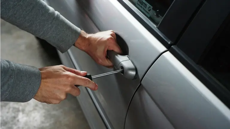 Un hombre intenta acceder al interior de un coche. ARCHIVO