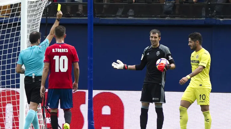 GRA411. VILLARREAL, 25/09/2016.- El portero del Osasuna Mario Fernández Cuesta (2d) recibe la tarjeta amarilla tras cometer penalti durante el partido de la sexta jornada de Liga que disputan frnete al Villarreal en el estadio el Sadar. EFE/Domenech Castelló