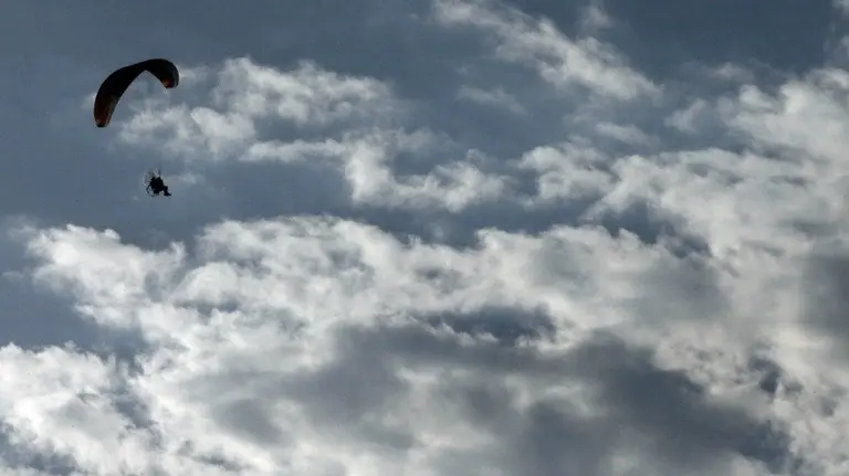 Un parapente con motor sobrevuela la localidad de Huarte. EFEDIGES