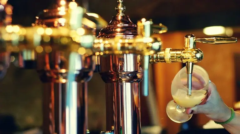 Un camarero pone cerveza en un bar. ARCHIVO