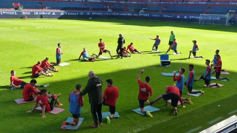 Los jugadores de Osasuna estiran en el estadio del Sadar.