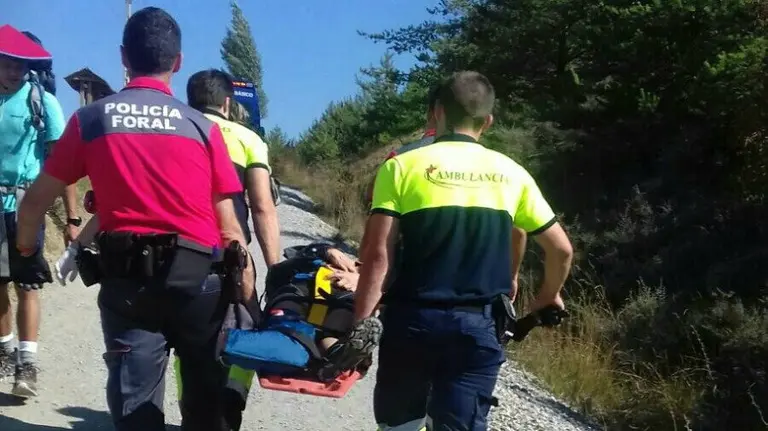 Un policía foral ayuda a los servicios de emergencia a trasladar a la mujer hasta la ambulancia. PFORAL