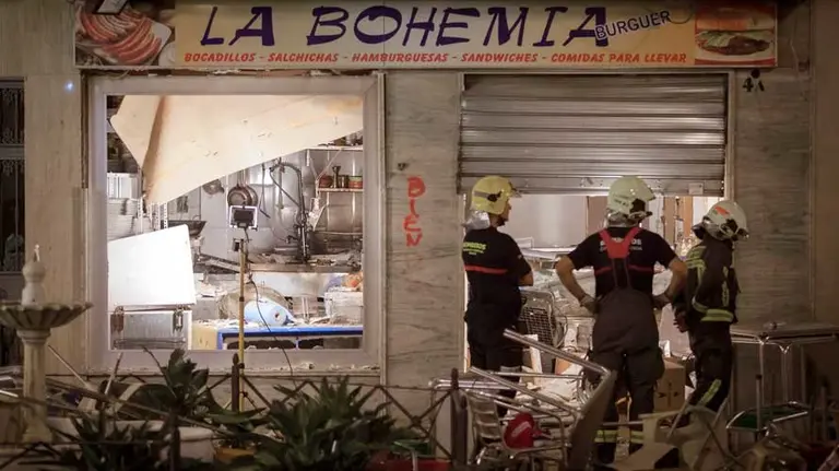 Los bomberos trabajan en la cafetería la Bohemia, donde ha tenido lugar la gran explosión de gas. EFE