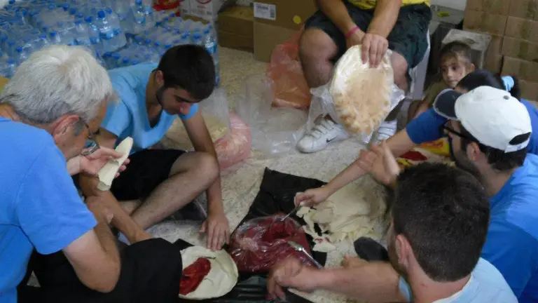 Georges Sabé, a la izquierda, prepara raciones de comida junto a personas voluntarias de los Hermanos Maristas de Alepo. CEDIDA